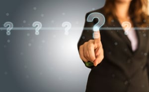 woman in business suit pointing at floating question mark